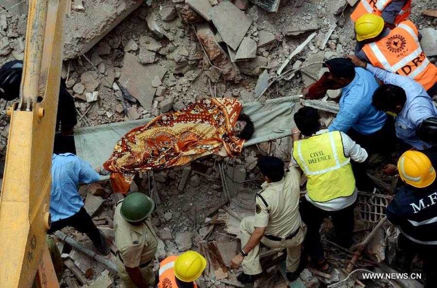 Rescuers work at the site of collapsed four-storey building in suburban Dahisar on the outskirts of Mumbai, on June 22, 2013.The building collapsed on Saturday caused five people dead and several wounded. (Xinhua/Stringer)