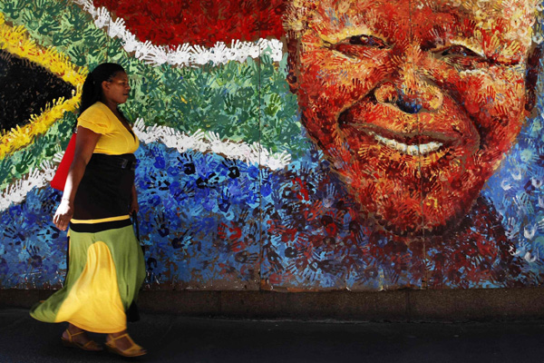 A pedestrian passes a handprint mural of Nelson Mandela in Cape Town February 11, 2010. [Xinhua] 