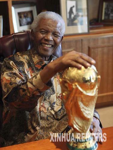 In this photo released by the Mandela Foundation, former South African President Nelson Mandela smiles as he holds the FIFA World Cup trophy, at the Mandela Foundation in Johannesburg, South Africa, May 6, 2010. [Xinhua]