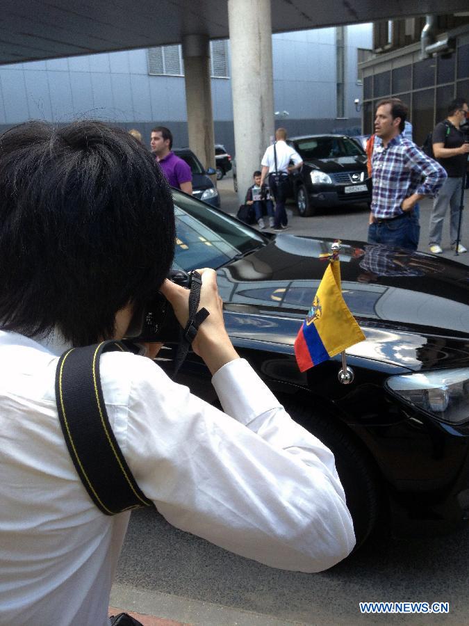 Media reporters work beside a vehicle of the Ecuadorian Embassy in Moscow, June 23, 2013. According to Russian media reports, Snowden arrived in Moscow from Hong Kong on Sunday on a commercial flight and the Ecuadorian ambassador in Moscow was waiting for him at the Sheremetyevo airport.