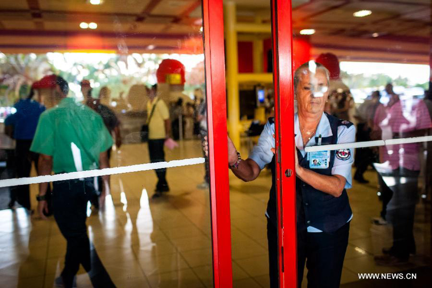 A staff closes an exit to the flight SU150 from Moscow, Russia, due to the emergency of too many journalists at the Jose Marti airport in Havana, Cuba, June 24, 2013. Former U.S. intelligence contractor Edward Snowden did not show up at the flight.