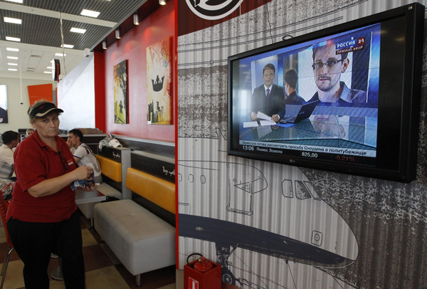 A television screens the image of former US spy agency contractor Edward Snowden during a news bulletin at a cafe in Moscow's Sheremetyevo airport on June 26, 2013. 