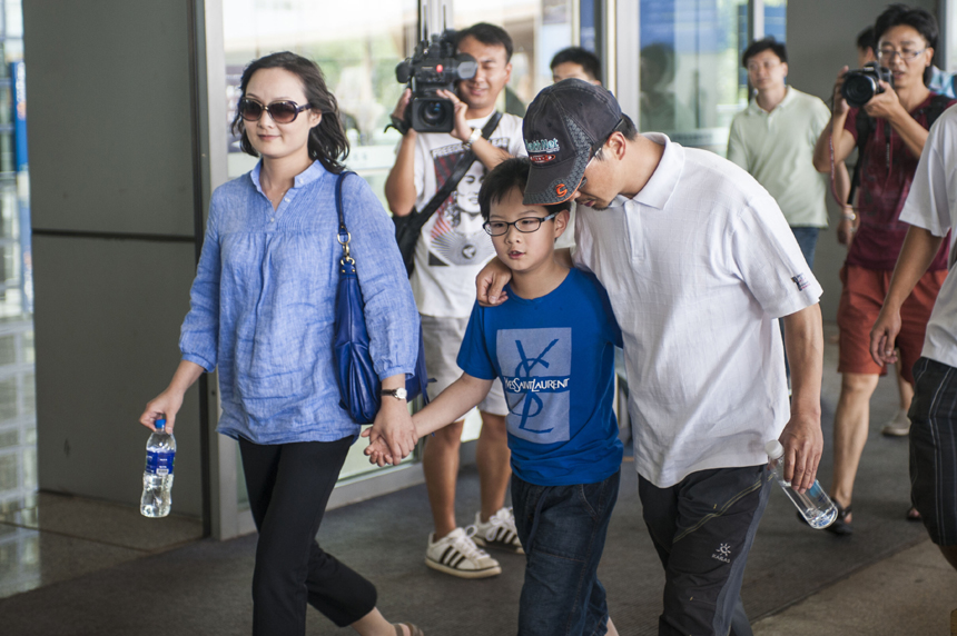 Zhang Jingchuan, the only survivor of a four-member Chinese amateur mountaineering team following a Taliban terrorist attack in northern Pakistan on Sunday, are greeted by his family at the airport in Kunming, Yunnan Province, on June 26. Two Chinese civilian mountaineers and a Chinese American were among the 11 people killed in a pre-dawn terrorist attack in Pakistan-administered Kashmir on Sunday. [Photo/Xinhua] 