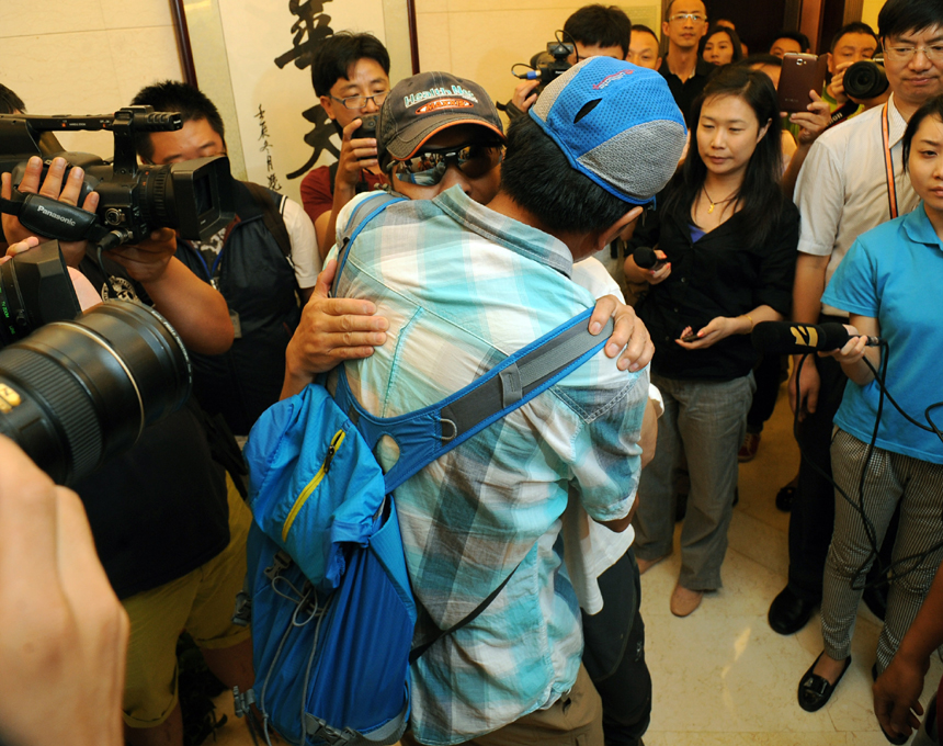 Zhang Jingchuan, the only survivor of a four-member Chinese amateur mountaineering team following a Taliban terrorist attack in northern Pakistan on Sunday, are greeted by his family at the airport in Kunming, Yunnan Province, on June 26. Two Chinese civilian mountaineers and a Chinese American were among the 11 people killed in a pre-dawn terrorist attack in Pakistan-administered Kashmir on Sunday. [Photo/Xinhua] 