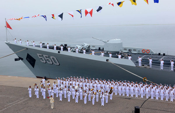 A brass band performs beside a Chinese naval ship before it departs to participate in Sino-Russian joint naval drills, at a port of Qingdao city, East China's Shangdong province on July 1, 2013.[Photo/Xinhua] 