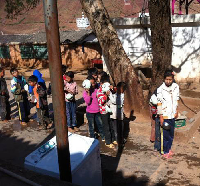 Pupils in Dongjiang Primary School in the town of Lijiang, Southwest China's Yunnan Province, queue for lunch. [Photo/Zhang Yunming]