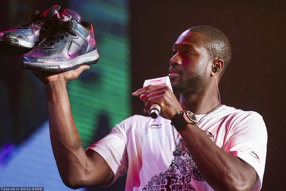 Dwayne Wade shows Li Ning's Way of Wade sneakers at a promotional event in Beijing on Wednesday.