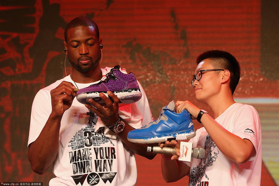 Wade signs his name on the sneaker. 