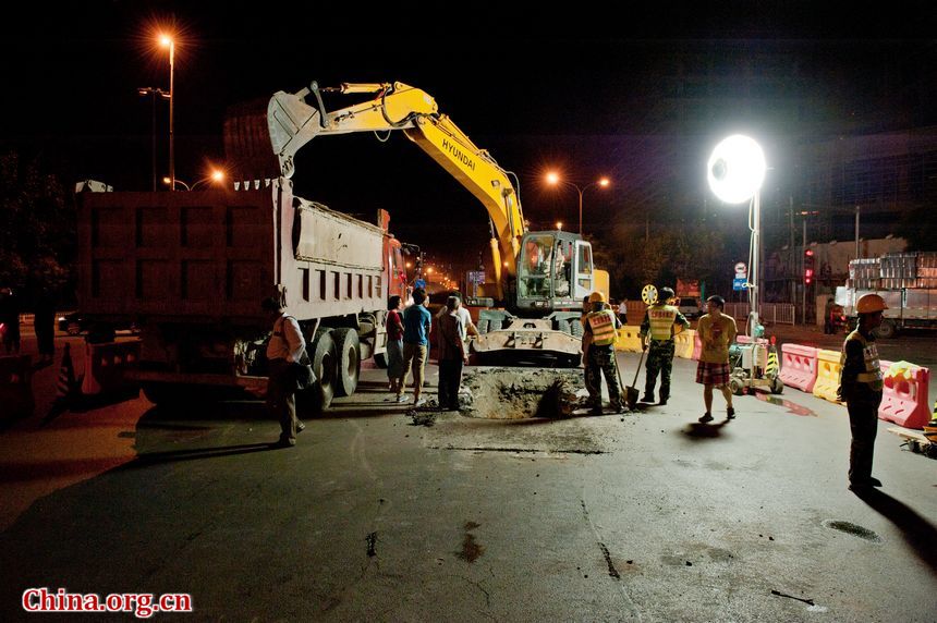 Public utility maintenance workers toil in sultry nightime conditions to fix burst water pipes in Yuquanlu, West Beijing on Wednesday, July 3, 2012. [Chen Boyuan / China.org.cn]