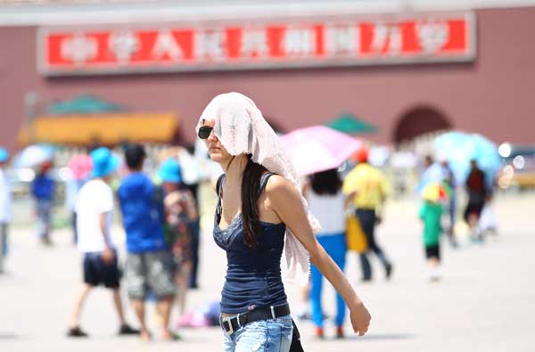 Tourists feel the heat in Tian'anmen Square, Beijing, on Wednesday when a temperature of 36 C was recorded at noon, a record-high since the start of summer, according to the city’s weather forecasters. [Photo/China Daily]