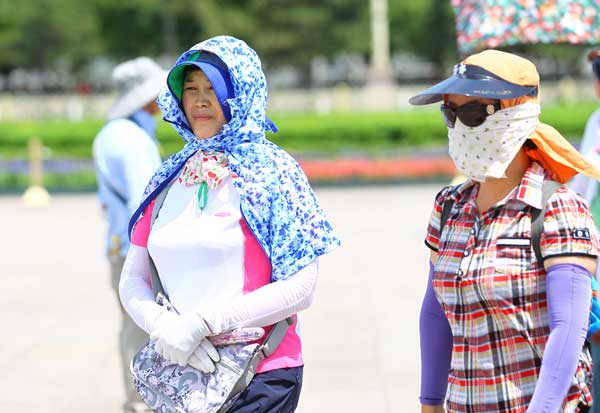 Tourists feel the heat in Tian'anmen Square, Beijing, on Wednesday when a temperature of 36 C was recorded at noon, a record-high since the start of summer, according to the city’s weather forecasters. [Photo/China Daily] 