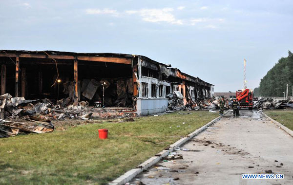 Fire fighters are pictured next to a burnt poultry slaughterhouse owned by the Jilin Baoyuanfeng Poultry Company in Mishazi Township of Dehui City in northeast China's Jilin Province, June 3, 2013. The death toll from the fire has risen to 119 as of 8 p.m. on Monday. Search and rescue work is under way. [Photo: Xinhua]