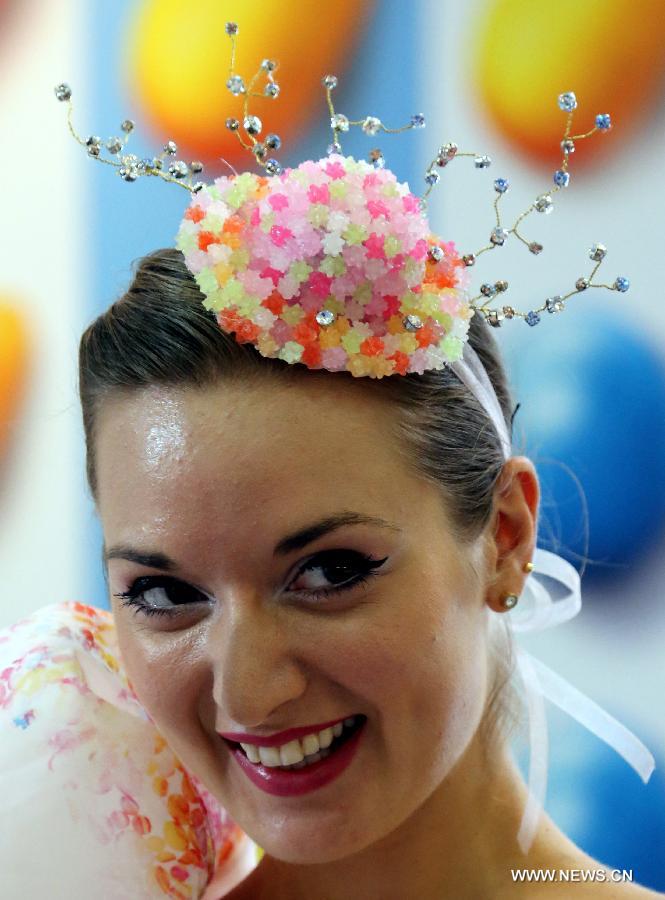 A model presents a headwear made of candies designed by Hong Kong designer Lilian Kan at Citygate Outlets in south China's Hong Kong, July 8, 2013. Kan showed her self-designed shoes and apparels made of candies on Monday. [Xinhua]