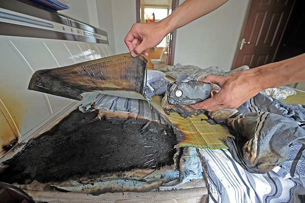 The charred remains after the iPhone 4 exploded in Wang Kai's bedroom in Chongqing, on July 9, 2013. [Photo by Yu Xiao/Asianewsphoto] 