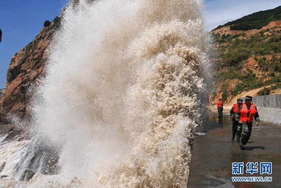 Giant waves surge up against the shoreline of Diaobin fishing port in Wenling city, East China's Zhejiang province, on July 12, 2013. 