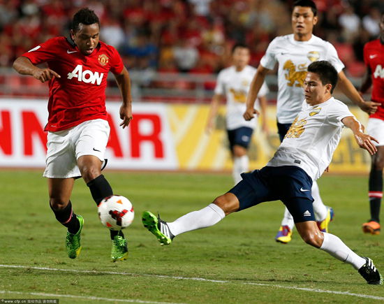 Manchester United's Brazilian midfielder Anderson (L) in action against Singha All Star team's Thitipan Puangchan (R) during the friendly soccer match between Manchester United and the Singha All Star team at Rajamangala National Stadium in Bangkok, Thailand on July 13, 2013.