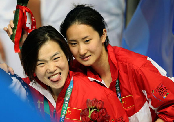 Zheng Shuangxue and Chen Ye pose for a photo on the podium after winning the women's synchronised 3m springboard at the Kazan Universiade in Kazan, Russia, July 12, 2013. [Photo/Xinhua]    