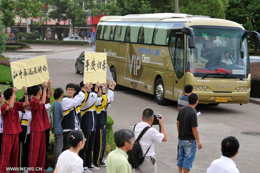 Students and teachers arrive at Jiangshan Middle School by bus in Jiangshan, east China's Zhejiang province, July 14, 2013. A total of 31 students and teachers who were held up in the U.S. by the crashed Asiana Airlines Flight 214 at the San Francisco International Airport returned to Beijing on Saturday and reached home on Sunday. 