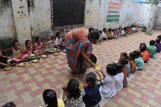 Indian schoolchildren at Jahangirpura Shala Number 2, which is run by the Ahmedabad Municipal Corporation, are served their free mid-day meal in Ahmedabad on July 17, 2013. Twenty-two children have died in India's Bihar state after eating a free lunch feared to contain poisonous chemicals at an Indian primary school, officials said July 17, as the tragedy sparked angry street protests. [Xinhua] 