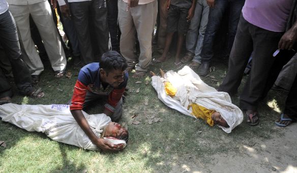 An Indian father grieves over the body of his child who consumed a free mid day meal, in Dharma Sati village in the Saran district of Bihar state on July 17, 2013. Twenty-two children have died after eating a free lunch feared to contain poisonous chemicals at an Indian primary school, officials said, as the tragedy sparked angry street protests. [Xinhua]