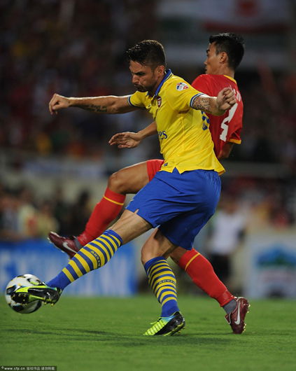 Olivier Giroud breaks past Vietnam defender Le Phuoc Tu to score for Arsenal during the pre-season Asian Tour friendly match between Vietnam and Arsenal at the My Dinh National Stadium on July 17, 2013 in Hanoi, Vietnam. 