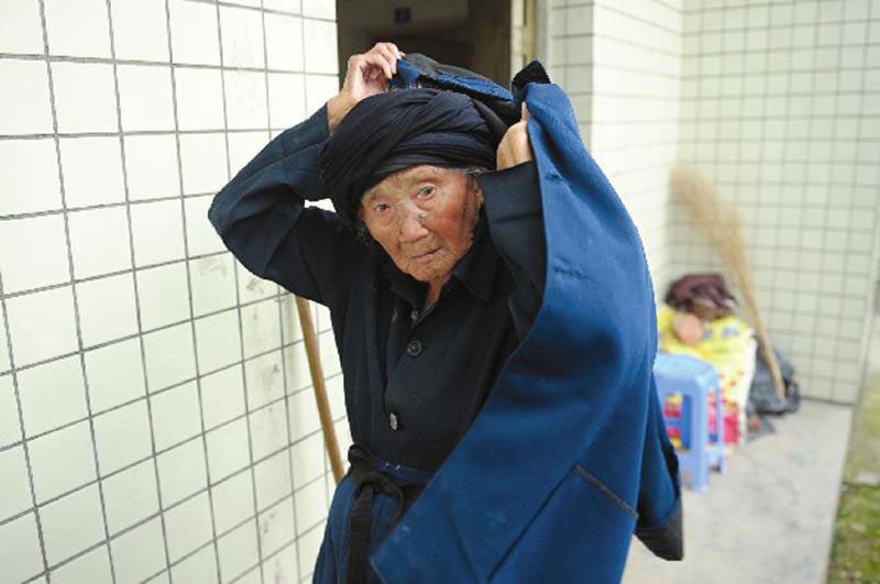 The world's oldest woman Fu Suqing, recognized as such by Carrying The Flag World Records, welcomes her 116th birthday on July 18, 2013. The organization produced a customized bronze medal of Fu and sent it to her village in Sichuan province to mark the occasion. [Photo/people.com.cn] 