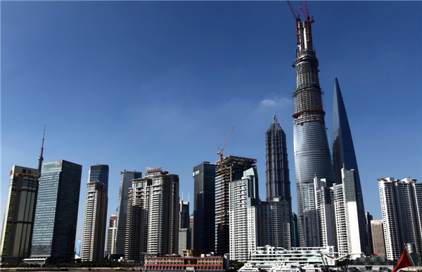 Shanghai Tower, China's tallest building when it's finished, dwarfs nearby skyscrapers in the Lujiazui finance and trade district in Shanghai's Pudong area, July 17, 2013. The structure will be capped soon with a spire, which will bring the dragon-shaped building to a height of 632 meters, dwarfing the 492-meter Shanghai World Financial Center and 421-meter Jinmao Tower. The building will be finished and open by 2015. [Photo/Xinhua] 