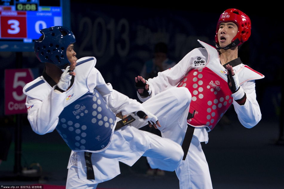 Huang Zhang Kun of China (red) competes against Arnold Owone of Gabon (blue) during a Men's -54 kg combat of WTF World Taekwondo Championships 2013 at the exhibitions Center on July 18, 2013 in Puebla, Mexico. 