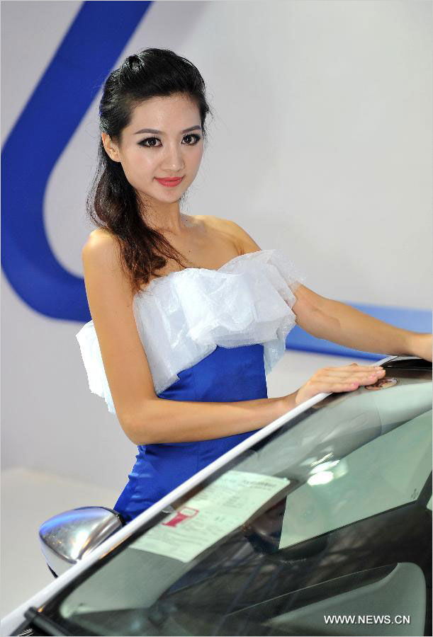 A model presents a car at the 2013 China Hainan International Automotive Exhibition in Haikou, capital of South China's Hainan province, July 18 2013. The four-day exhibition closed on July 21, attracting 100 automobile manufacturers. [Photo / Xinhua] 