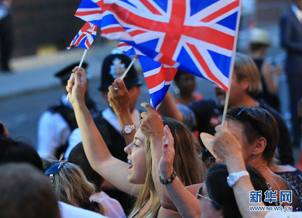 People celebrate the birth of a new royal baby outside St. Mary's Hospital in London, July 22, 2013. [Xinhua]