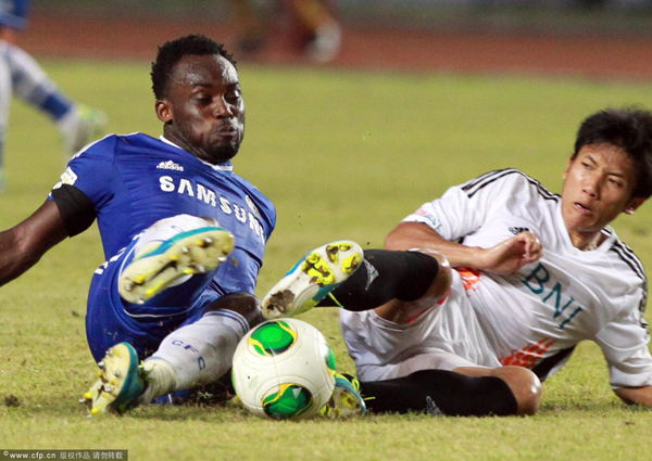 Michael Essien (L) and Indonesian Ahmad Bustomi (R) in action during a friendly match between Indonesia All Star and Chelsea in Jakarta, Indonesia 25 July 2013. 