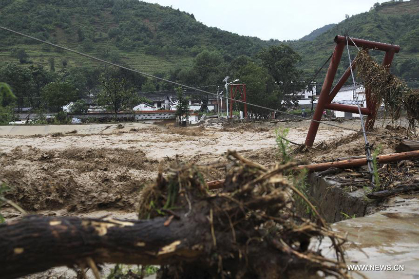 A bridge linking Baiwan Village and outside is swept away by flood in Chengxian County of Longnan City, northwest China&apos;s Gansu Province, July 25, 2013. A torrential rain battered Chengxian County Wednesday night, causing landslips, collapses and traffic disrupted. A total of 1,060 residents have been evacuated by now. 