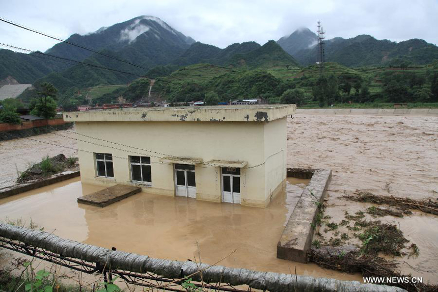 A house is submerged at Huangzhu Town of Chengxian County in Longnan City, northwest China&apos;s Gansu Province, July 25, 2013. A torrential rain battered Chengxian County Wednesday night, causing landslips, collapses and traffic disrupted. A total of 1,060 residents have been evacuated by now.