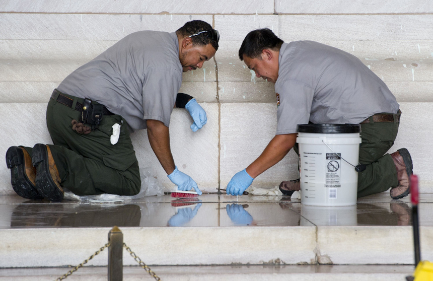 Workers with the National Park Service cleans off paint thrown on the Lincoln Memorial overnight by vandals on the National Mall in Washington, DC, July 26, 2013.