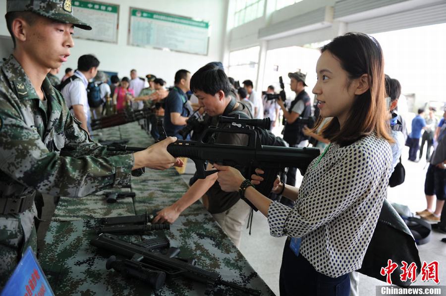 The air defence brigade of the 47th army group of the Chinese People's Liberation Army (PLA) Ground Force opens to the press on Monday, July 29, 2013. Journalists from 48 domestic and overseas media organizations visit the brigade's garrison in Lintong district in Xi'an city, northwest China's Shaanxi province. Pictured: A PLA soldier introduces a Type 95 Assault Rifle to a journalist. [Photo/China News Service]