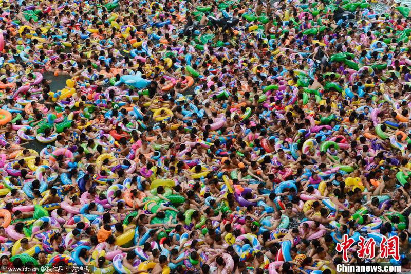 People cram in a water pool to cool off themselves inside a scenery spot in Daying County, Suining, southwest China's Sichuan Province, July 28, 2013. [Photo/Chinanews.com] 