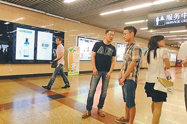 Ruan Qi (third from right) gives instructions to one of his students on how to chat with girls at a Shanghai subway station. [Gao Erqiang / China Daily] 