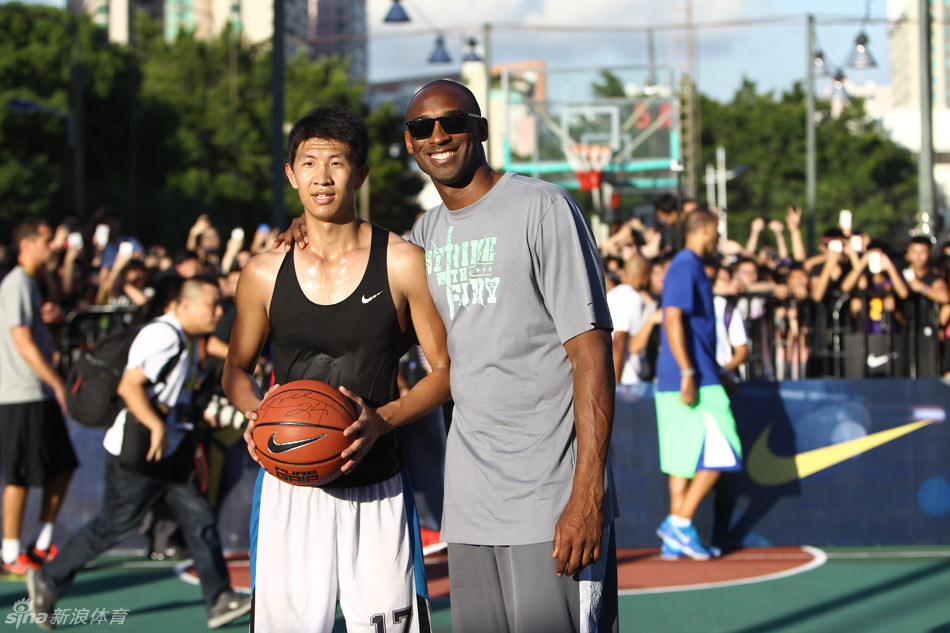 8月4日，NBA篮球巨星科比·布莱恩特到访深圳，开启今夏科比中国篮球之旅第二站活动。图为科比现场指导一名篮球爱好者并与其合影。[李欣 摄]