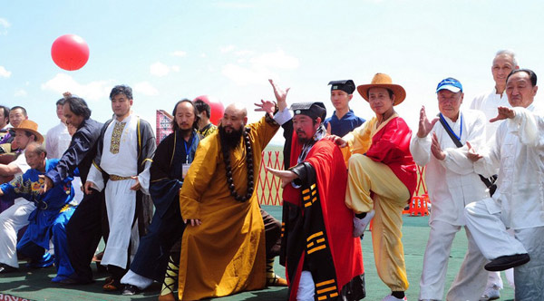 Masters of martial art pose for a group photo during the Tianshan Mountain Cultural Week in Tekes county, Ili Kazak autonomous prefecture of Xinjiang Uygur autonomous region, August 3, 2013. Representatives from 11 factions ofwushu, or Chinese martial arts displayed their skills.[Photo/chinanews.cn]