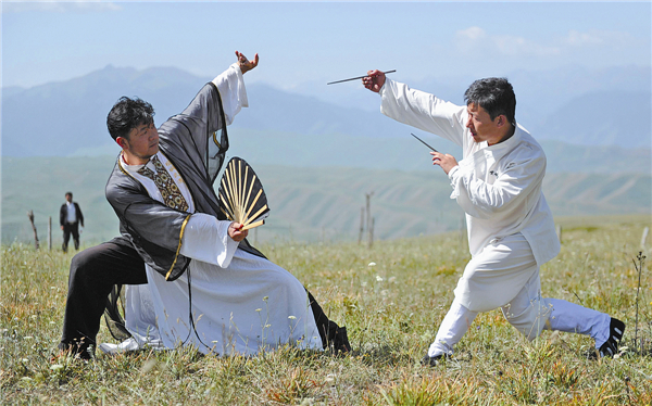 Representatives from different schools of Wushu, a traditional Chinese martial art, demonstrate their skills on the grasslands near Tianshan Mountain for a kung fu show this week. They were criticized online for putting on a show rather than popularizing martial arts. [Photo/China Daily]