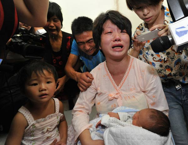Lai Guofeng's wife holds her baby rescued by police in Fuping, Shaanxi province, Aug 5, 2013. [Photo/Xinhua] 