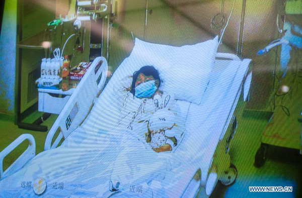 Photo taken on April 13, 2013 shows a screen showing a seven-year-old girl, who was infected with the H7N9 strain of bird flu, receiving medical treatment in the Beijing Ditan Hospital, during a press conference held by the hospital in Beijing, capital of China. [Photo/Xinhua] 