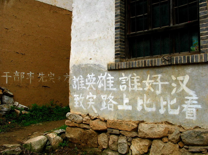 The white slogan reads 'Who is the true hero? The answer can be seen on the road of striving for richness.' It is meant to encouraging people to lift themselves from poverty. [Photo by Ma Hongjie provided to chinadaily.com.cn] 