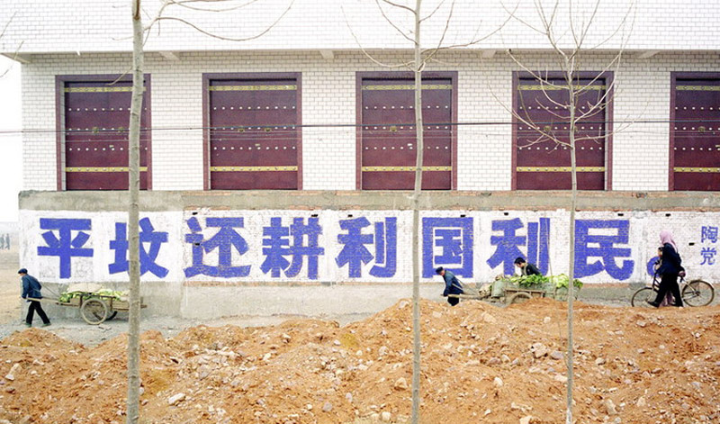 The slogan reads 'Flattening tombs to return farmland is beneficial to both the nation and people.' [Photo by Ma Hongjie provided to chinadaily.com.cn] 