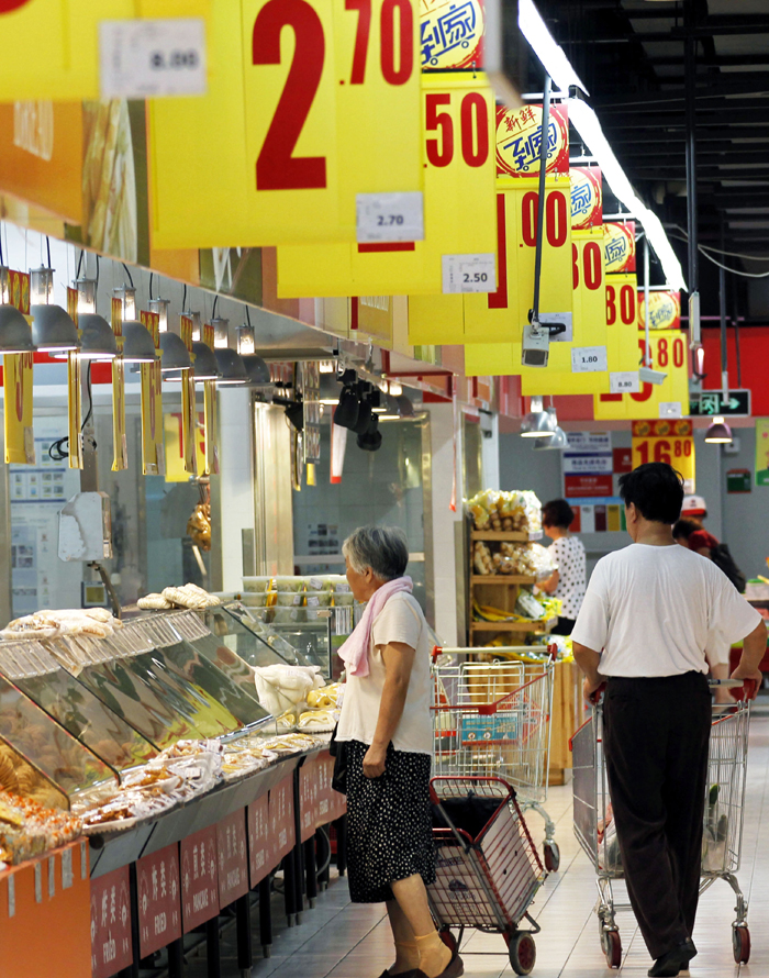 Citizens select products at a market in Shanghai, east China, Aug. 9, 2013. China's consumer price index (CPI), a main gauge of inflation, grew 2.7 percent year on year in July, staying flat from the figure for June, the National Bureau of Statistics (NBS) announced on Friday.