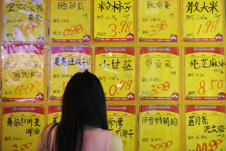 A customer checks product information at a supermarket in Yinchuan, capital of northwest China's Ningxia Hui Autonomous Region, Aug. 8, 2013. China's consumer price index (CPI), a main gauge of inflation, grew 2.7 percent year on year in July, staying flat from the figure for June, the National Bureau of Statistics (NBS) announced on Friday.