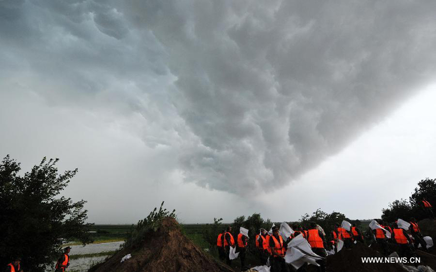 A contingent of local armed police forest corps consolidate the bank of the Heilongjiang River in Sunwu County of Heihe City, northeast China&apos;s Heilongjiang Province, Aug. 8, 2013. Continuous downpours since July left floodwater from tributaries to flow into the Heilongjiang River, putting much pressure on flood control in the lower reaches. As of Tuesday, the water level of the Heilongjiang River in Heihe reached 96.66 meters, surpassing the record level recorded in 1998 by 0.6 meters.