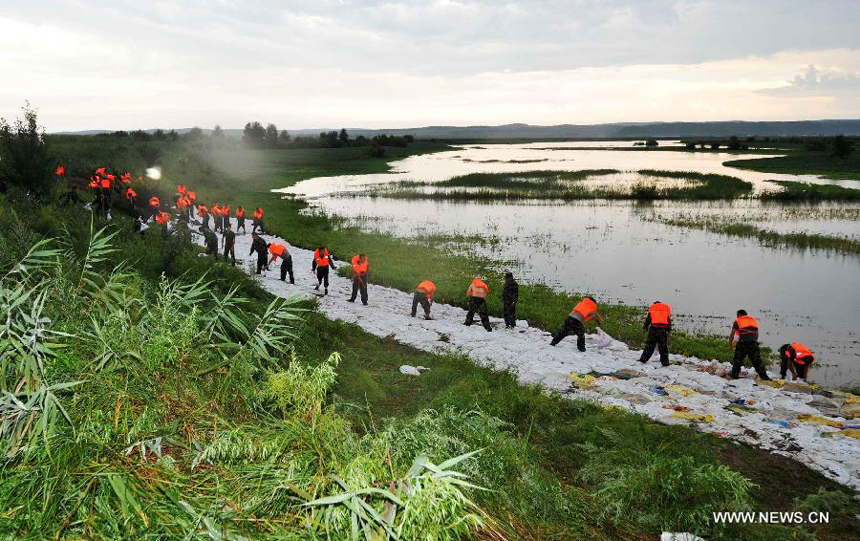 Local firemen consolidate the bank of the Heilongjiang River in Sunwu County of Heihe City, northeast China&apos;s Heilongjiang Province, Aug. 8, 2013. Continuous downpours since July left floodwater from tributaries to flow into the Heilongjiang River, putting much pressure on flood control in the lower reaches. As of Tuesday, the water level of the Heilongjiang River in Heihe reached 96.66 meters, surpassing the record level recorded in 1998 by 0.6 meters.