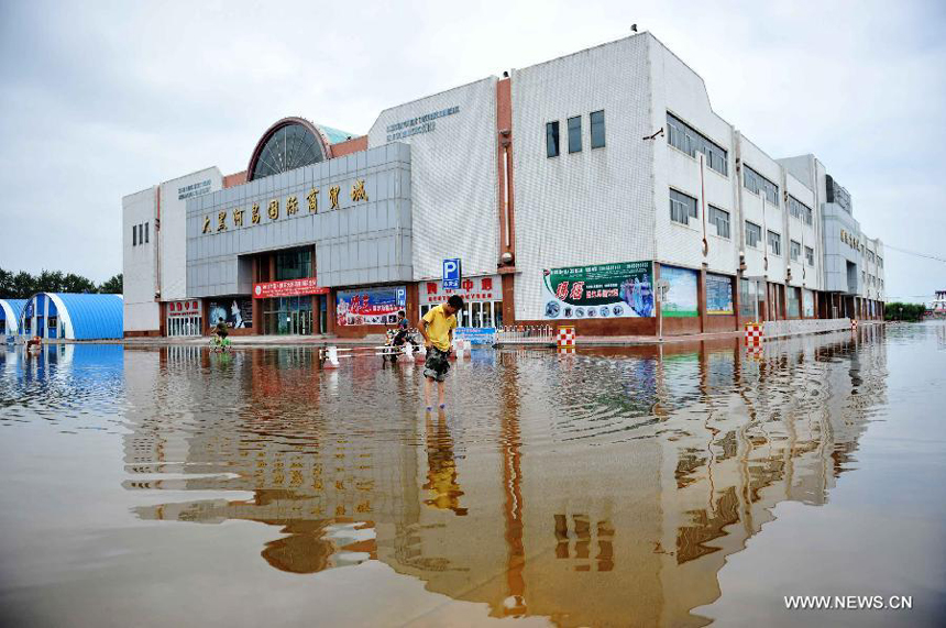 A commercial estate is besieged by flood on the Daheihe Island in Heihe City, northeast China&apos;s Heilongjiang Province, Aug. 8, 2013. Continuous downpours since July left floodwater from tributaries to flow into the Heilongjiang River, putting much pressure on flood control in the lower reaches. As of Tuesday, the water level of the Heilongjiang River in Heihe reached 96.66 meters, surpassing the record level recorded in 1998 by 0.6 meters.