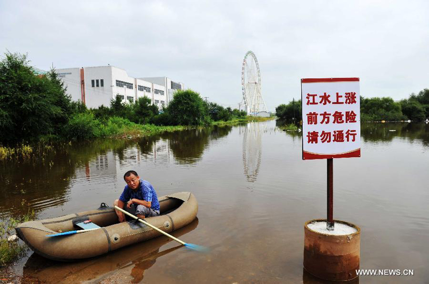 A man sits in a raft beside a notice board warning the swollen Heilongjiang River on the Daheihe Island in Heihe City, northeast China&apos;s Heilongjiang Province, Aug. 8, 2013. Continuous downpours since July left floodwater from tributaries to flow into the Heilongjiang River, putting much pressure on flood control in the lower reaches. As of Tuesday, the water level of the Heilongjiang River in Heihe reached 96.66 meters, surpassing the record level recorded in 1998 by 0.6 meters. 